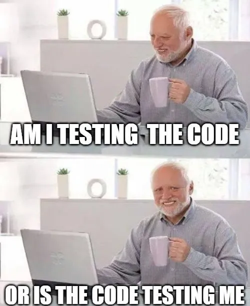 Älterer Mann arbeitet am Laptop und fragt sich, wer wen beim Programmieren testet. Älterer Mann mit grauem Bart sitzt vor einem Laptop, hält eine Tasse und lächelt, Text über und unter ihm besagt: Am I testing the code or is the code testing me